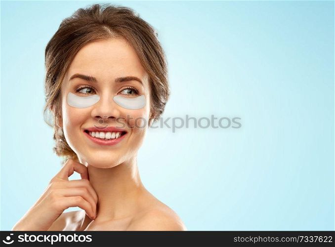 beauty, cosmetology and rejuvenation concept - beautiful young woman face with hydrogel under-eye patches over blue background. beautiful young woman face with under-eye patches