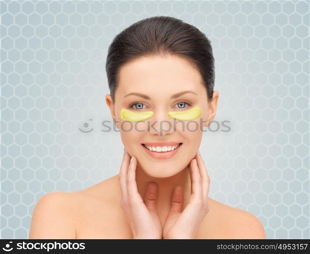 beauty, cosmetology, hydration, people and rejuvenation concept - beautiful young woman face with hydrogel under-eye patches over gray background. beautiful young woman face with under-eye patches