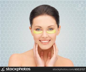 beauty, cosmetology, hydration, people and rejuvenation concept - beautiful young woman face with hydrogel under-eye patches over gray background. beautiful young woman face with under-eye patches