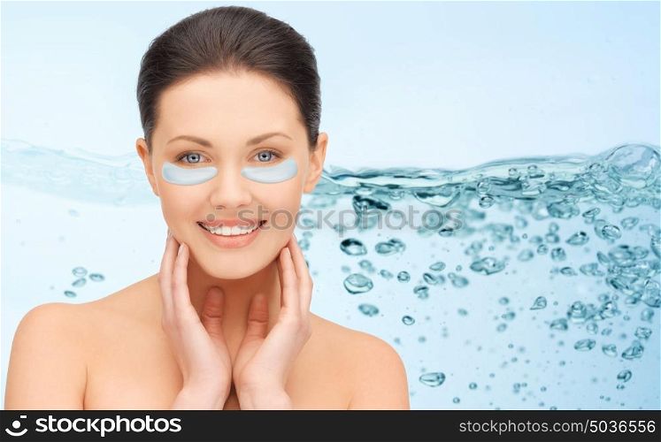 beauty, cosmetology, hydration, people and rejuvenation concept - beautiful young woman face with hydrogel under-eye patches over blue background and water bubbles. beautiful young woman face with under-eye patches