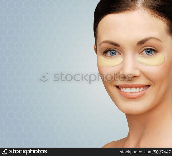 beauty, cosmetology, hydration, people and rejuvenation concept - close up of beautiful young woman face with hydrogel under-eye patches over gray background. close up of woman face with under-eye patches
