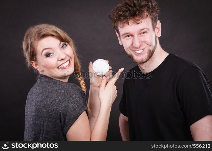 Beauty cream health concept. Young couple and skin care. Girl puts cream on man face.. Young couple and skin care.