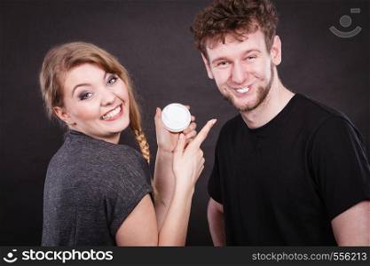 Beauty cream health concept. Young couple and skin care. Girl puts cream on man face.. Young couple and skin care.