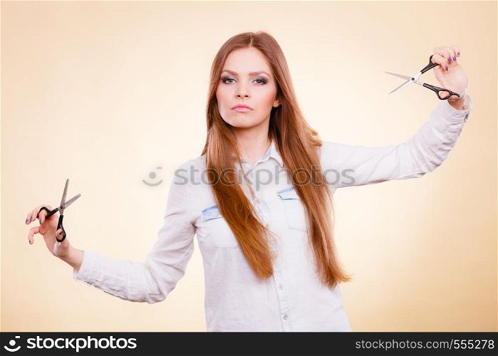 Beauty danger haircut coiffure care concept. Smiling lady showing tools. Young cheerful irresponsible hairdresser waving around razor sharp scissors.. Smiling lady showing tools.