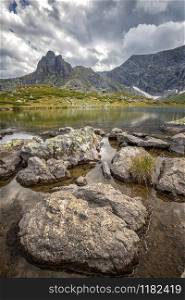 beauty day landscape on the mountain lake with rocks at the front. Vertical view