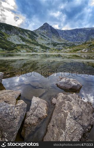 beauty day landscape on the mountain lake with rocks at the front. Vertical view
