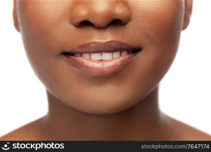 beauty, dental care and people concept - close up of face of beautiful smiling young african american woman over white background. close up of face of smiling african american woman