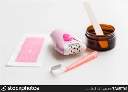 beauty, depilation and hair removal concept - epilator, safety razor, wax with spatula and patch on white background. safety razor, epilator, hair removal wax and patch