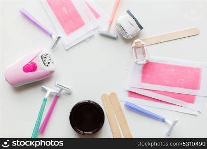 beauty, depilation and hair removal concept - wax with spatula, epilator and safety razor on white background. hair removal wax, epilator and safety razor