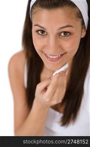 Beauty facial care - Teenager woman cleaning acne skin with cotton pad on white background