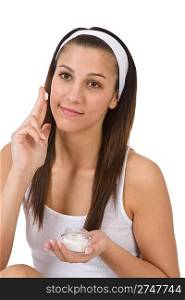 Beauty facial care - Young woman apply moisturizer on white background