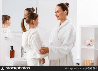 beauty, family and people concept - happy smiling mother and little daughter in bathroom. happy smiling mother and daughter in bathroom