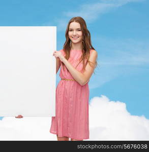 beauty, fashion, advertising and happy people concept - young woman in dress with white blank board