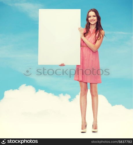 beauty, fashion, advertising and happy people concept - young woman in dress with white blank board