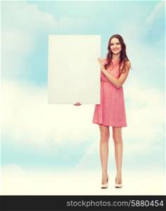 beauty, fashion, advertising and happy people concept - young woman in dress with white blank board