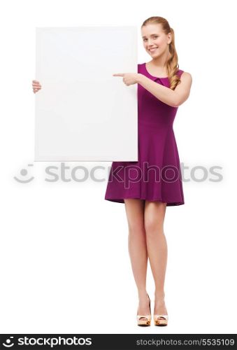 beauty, fashion, advertising and happy people concept - young woman in purple dress and high heels pointing finger to white blank board