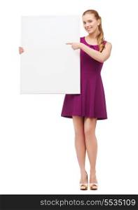 beauty, fashion, advertising and happy people concept - young woman in purple dress and high heels pointing finger to white blank board