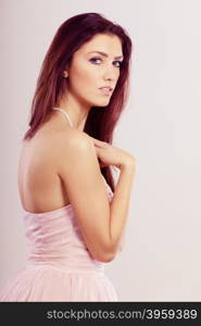 Beauty, fashion and elegant people concept - young brunette slim woman in bright dress bare shoulders pearls beads on neck