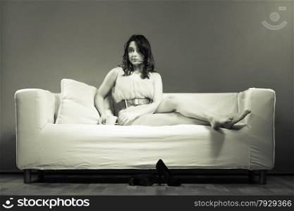 Beauty fashion and relax concept. Fashionable girl holding hot drink coffee or tea cup, sitting on sofa b&amp;w photo