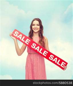 beauty, fashion, shopping and happy people concept - young woman in dress with sale sign