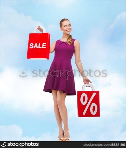 beauty, fashion, shopping and happy people concept - young woman in purple dress and high heels with sale and discount shopping bags