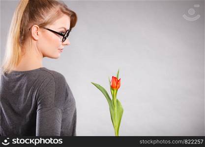 Beauty feelings seduction nature flora feminine concept. Elegant woman with flower. Lady in glasses holding blood red tulip smiling.. Elegant woman with flower.