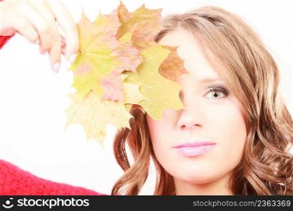 Beauty female autumnal model. Attractive girl long hair wearing warm red sweater with maple leaves in hand