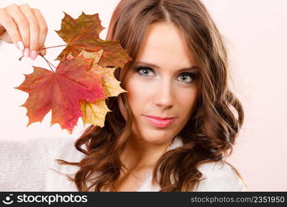 Beauty female autumnal model. Pretty girl long hair with maple leaves in hand