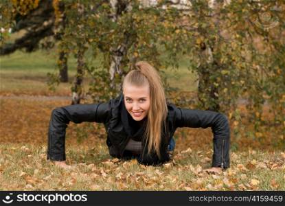 Beauty female doing push ups in the park