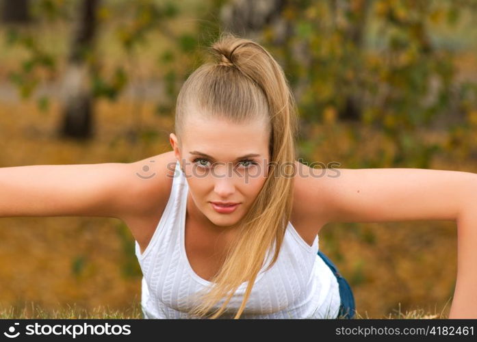 Beauty female doing push ups in the park