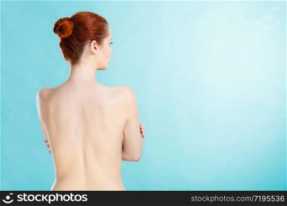 Beauty female figure, body care concept. Attractive red hair naked sensual woman back view. Pertect clean soft skin. Young woman with naked back