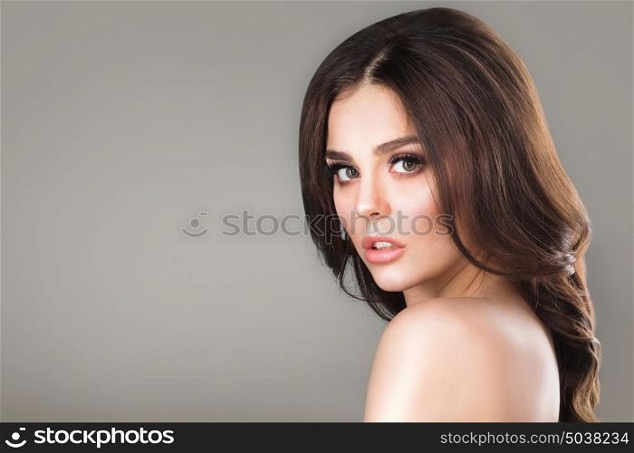 Beauty female portrait. Beauty portrait of young woman with naked shoulder on gray background