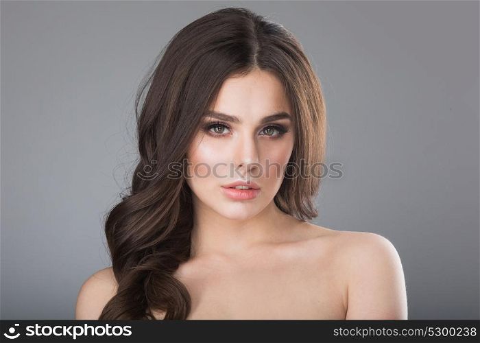 Beauty female portrait. Beauty portrait of young woman with naked shoulder on gray background