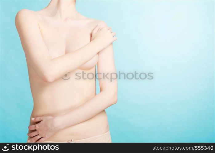 Beauty female slim figure, body care concept. Attractive naked sensual woman covering her breast with hands. Pertect clean soft skin. Bare woman covering her breast with hands