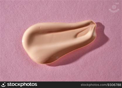 Beauty foundation swatch with spf on a pink background.. Foundation swatch with spf on a pink background.