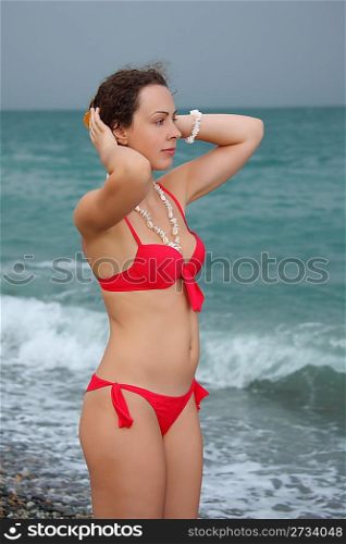 beauty girl stands on stormy beach