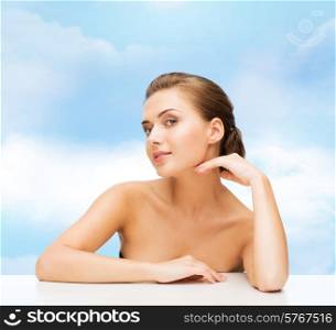beauty, health and people concept - smiling beautiful woman with clean perfect skin over blue cloudy sky background