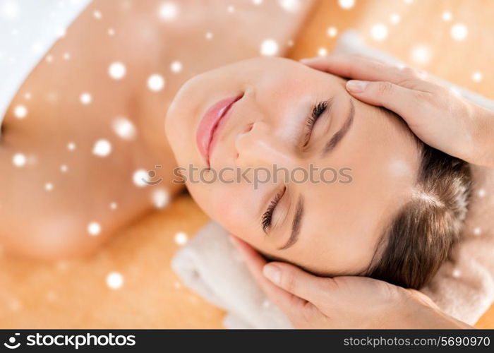 beauty, health, holidays, people and spa concept - beautiful woman in spa salon getting face or head massage