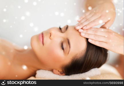 beauty, health, holidays, people and spa concept - beautiful woman in spa salon getting face or head massage