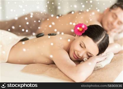 beauty, health, holidays, people and spa concept - happy couple with closed eyes getting hot stone massage in spa salon