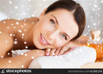 beauty, health, people and spa concept - beautiful young woman with body oil in spa