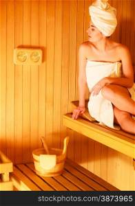 Beauty health spa concept. Woman relaxing in sauna interior looking on equipment thermometer and hygrometer.