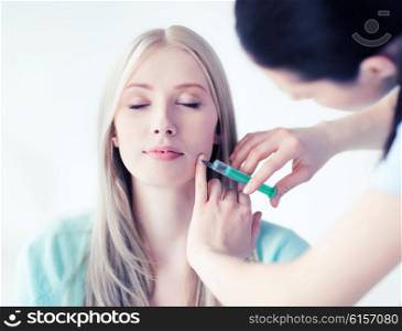 beauty, healthcare and medical concept - beautician with patient doing anti-aging injection in hospital