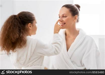 beauty, hygiene, morning and people concept - happy smiling mother and daughter having fun in at bathroom. happy smiling mother and daughter at bathroom