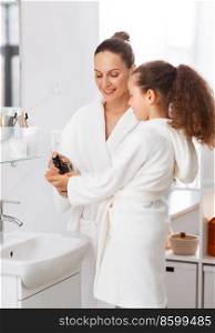 beauty, hygiene, morning and people concept - happy smiling mother and little daughter with liquid soap in bathroom. mother and daughter with liquid soap in bathroom