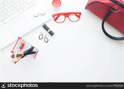 Beauty items in shopping cart with laptop computer on white background, Online shopping