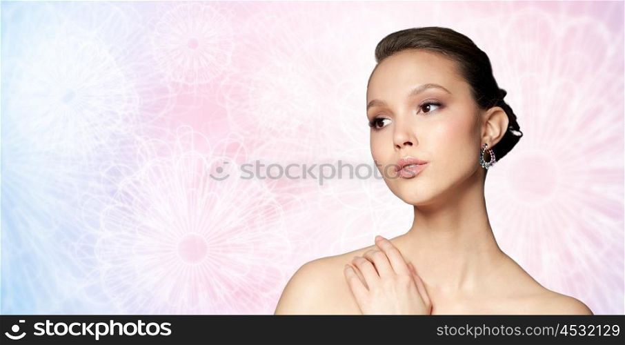 beauty, jewelry, accessories, people and luxury concept - close up of beautiful asian woman face with earring over rose quartz and serenity patterned background