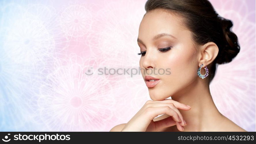 beauty, jewelry, accessories, people and luxury concept - close up of beautiful asian woman face with earring over rose quartz and serenity patterned background