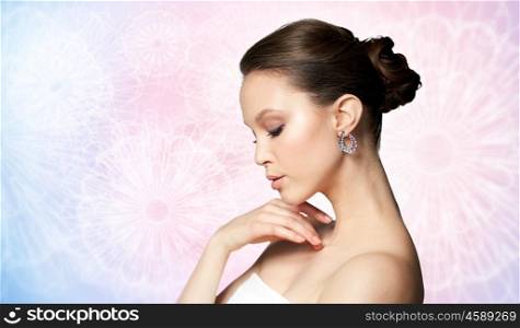 beauty, jewelry, accessories, people and luxury concept - close up of beautiful asian woman face with earring over rose quartz and serenity patterned background