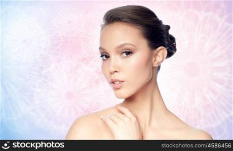 beauty, jewelry, accessories, people and luxury concept - face of beautiful young asian woman with golden ring over rose quartz and serenity patterned background
